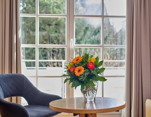 Sitzecke mit Sessel und Blumenstrauß im 3-Sterne-Hotel Schweizerhof, Villingen-Obereschach